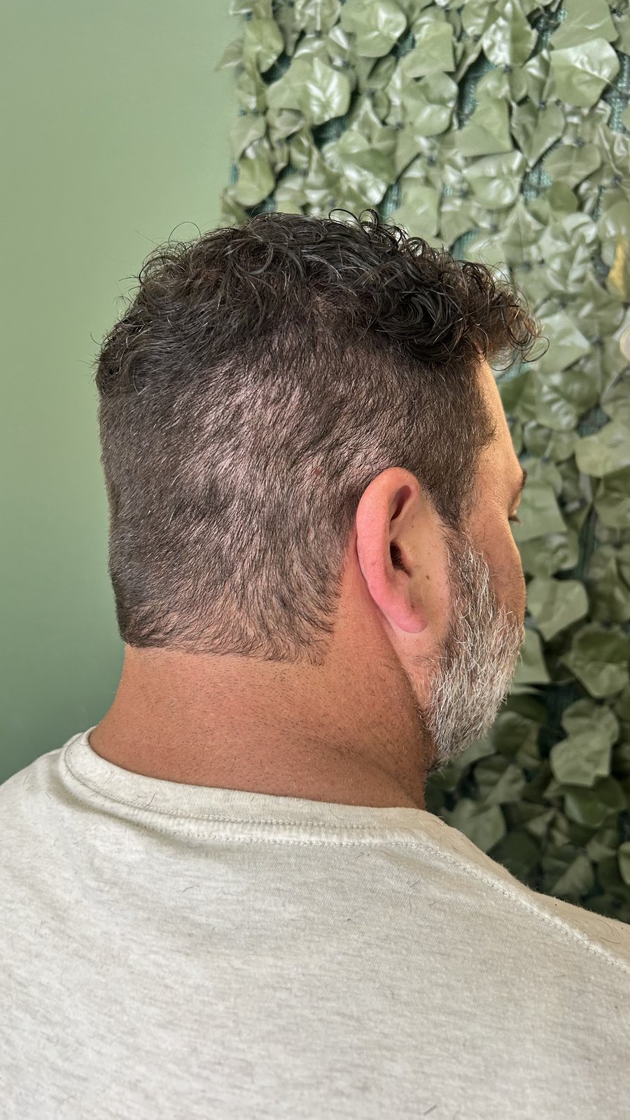 Men's cut: textured curly top with skin fade.
