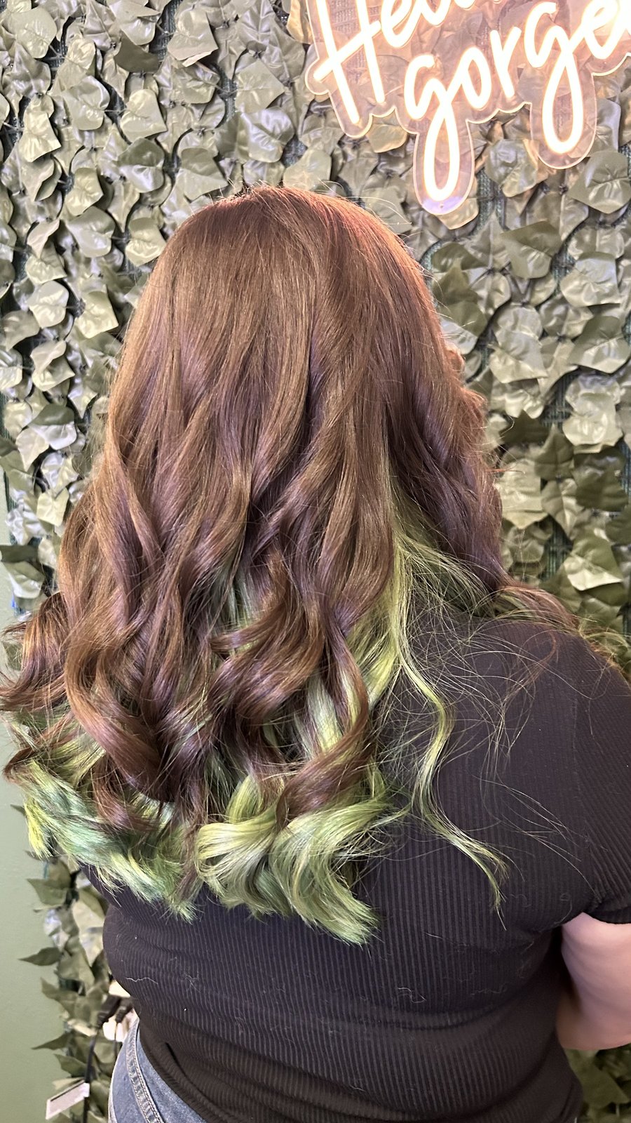 Vivid green peekaboo underlights against a brunette base.
